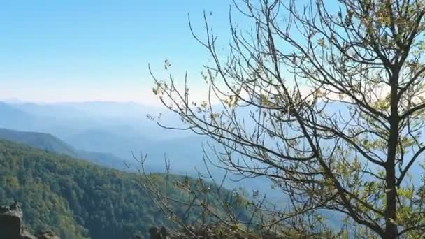 Berglandschaft. In der Ferne sind Bergkämme durch Dunst zu sehen. Im Vordergrund sind Steine. — Stockvideo