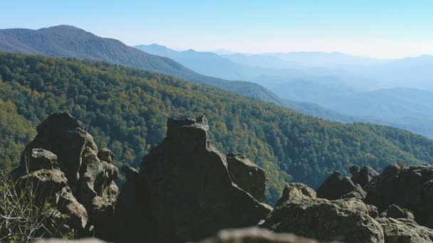 山の風景。遠くには、ヘイズを通して山の尾根を見ることができます。前景には石がある. — ストック動画