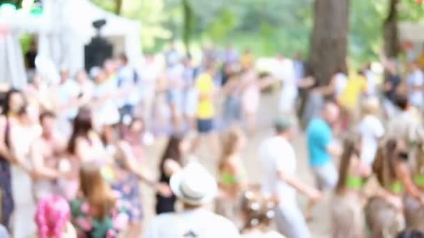 Summer party outdoors. Blurred background with dancing people in colorful clothes in forest, park, outdoors. Unrecognizable faces. — Stock Video
