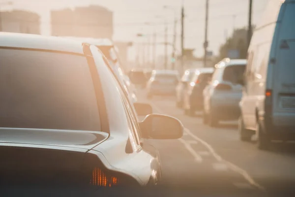 Das Heck eines unbekannten Autos bei Sonnenuntergang auf der stark befahrenen Straße. — Stockfoto