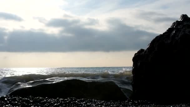 Waves roll onto the shore of the sea or ocean at sunset. Slow motion. — Stock Video