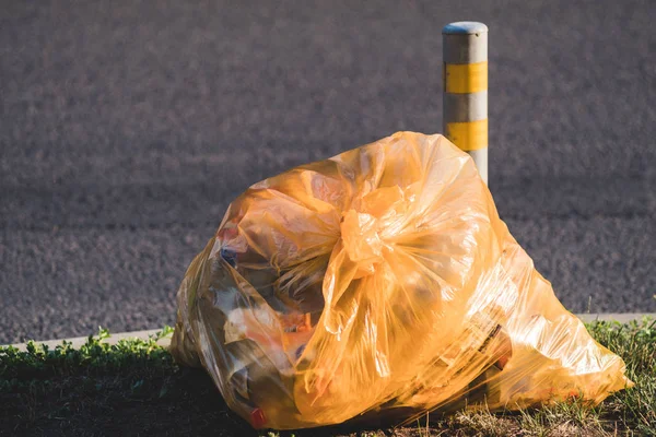 Мусорный пластиковый пакет лежит на обочине дороги. Экологические проблемы . — стоковое фото