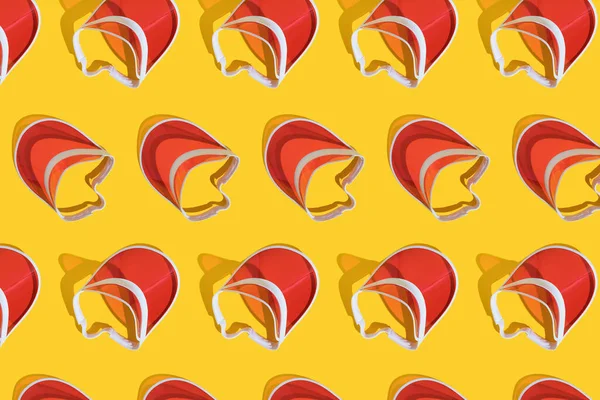 Bright red sports sun cap on a yellow background with a hard shadow. Creative texture food banner. Top view. Flat lay.