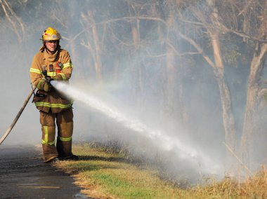 Melbourne, Avustralya - 13 Nisan 2018: itfaiyeci banliyö yüzölçümü Knox şehir Melbourne Doğu bush yangın, bir hortum ile.