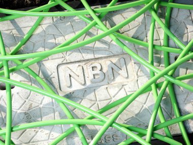 Melbourne, Avustralya - 14 Mayıs 2018: Yeşil Nbn fiber optik kablo Nbn kelime işareti görüntüleniyor Beton adam deliği kapağı ile bir çukur üzerinde yapılandırılmamış bir karmaşa