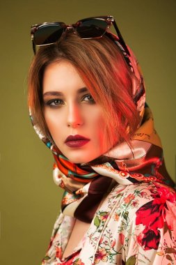 Bir kız, güzel bir eşarp ve güneş gözlüğü model portresi. S