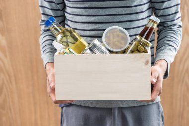 Gönüllü bağış kutusu ahşap arka plan üzerinde gıda ile tutarak