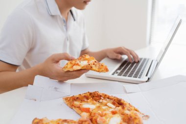 adam el dizüstü bilgisayar içinde çalışma pizza yemek kadar kapatın