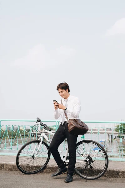 自転車や携帯電話を持つ青年実業家 — ストック写真