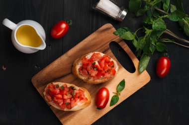 Lezzetli İtalyan bruschetta ekmek Domates ve ahşap tahta üzerinde otlar ile tepesinde ile