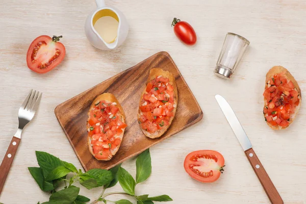 Lezzetli İtalyan bruschetta ekmek Domates ve ahşap tahta üzerinde otlar ile tepesinde ile