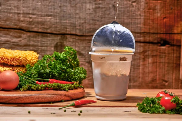 instant noodle, asian fast food, noodle cup on wooden background.