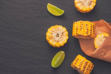 Siyah taş zemin üzerine soğan soslu lezzetli tatlı ızgara mısır.