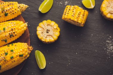 Siyah taş zemin üzerine soğan soslu lezzetli tatlı ızgara mısır.