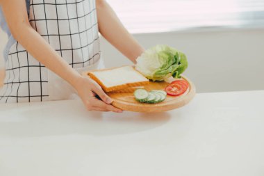 Kadın mutfakta kahvaltı hazırlarken önlük