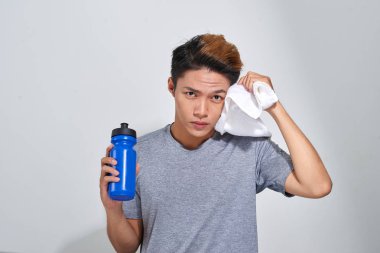 Yakışıklı genç adam su şişesi ve havlu ile yerleştirmek