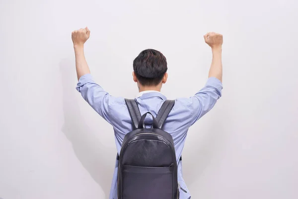 Back view of man with backpack posing with hands up on white background