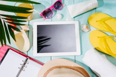 Tablet bilgisayar ile sahilde kum plaj öğeleri, üstten görünüm boş perde. Yaz arka plan