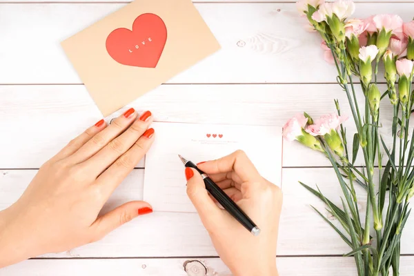 Vrouw Schrijft Liefdesbrief Wit Papier Met Rood Hart Vorm Cijfers — Stockfoto