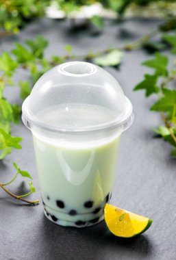 Kireç tablo ile plastik kap içinde ev yapımı süt kabarcık çay ve tapyoka inci.