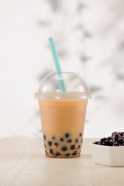 Ev yapımı süt kabarcık çay tablo üzerinde plastik bardak.