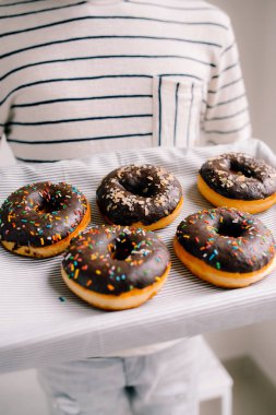 Beyaz zemin üzerine çikolatalı çörek kutusuyla holding erkek eller