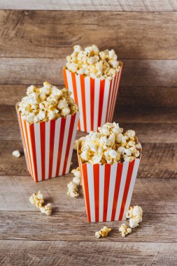 Patlamış mısır ahşap masa üzerinde kırmızı ve beyaz karton.