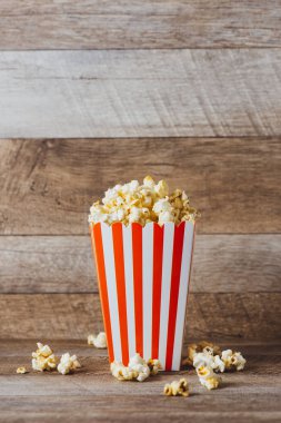 Patlamış mısır ahşap masa üzerinde kırmızı ve beyaz karton.