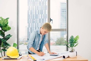 Ofisteki çizim masasında çalışan mimar