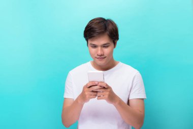 Genç adam akıllı telefon üzerinde mavi arka plan izole manifatura iletide