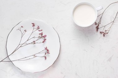 Süt cam ve beyaz masaya çiçek. Sağlıklı beslenme kavramı