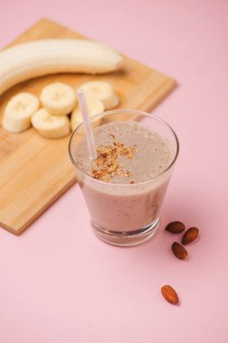 Muz smoothie muz, süt, beyaz masa, üstten görünüm, yatay, seçici odak cam bardaklarda badem