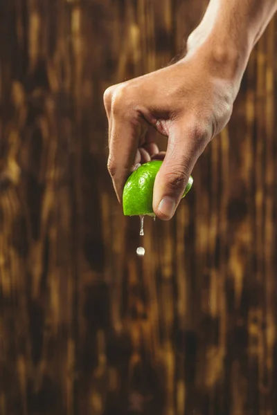 Mano Exprimir Cal Con Gota Cal Sobre Fondo Madera —  Fotos de Stock