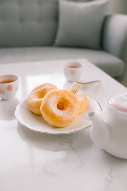 Beyaz arkaplanda şekerli çörek ve çay