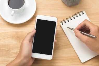 Akıllı telefon ve beyaz boş boş ekran kalemiyle beyaz Resepsiyon masasında tutan adam el. İş kavramı.