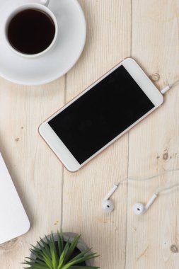 Fincan kahve ve ahşap arka plan üstünde smartphone