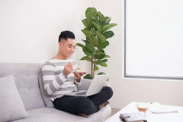 Homem Feliz Trabalhando Com Laptop Comer Bolo Sofá — Fotografia de Stock