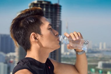 Dışarıdaki şişeden su içen bir adama yaklaş.