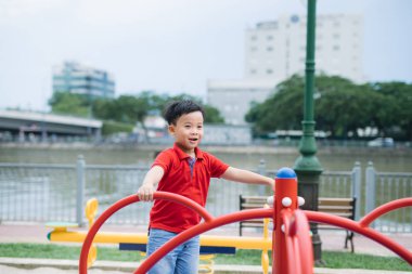 Küçük Asyalı çocuk bir salıncak sürme ve sevinir