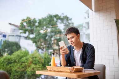 Mobil akıllı telefon, Internet kablosuz iletişim ile şeyler tarzının ve Internet ile smartphone kullanarak çay vaktinde telefon kullanıyor.