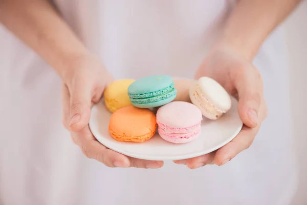 Mãos Femininas Segurando Placa Com Macaroons Pastel Coloridos — Fotografia de Stock