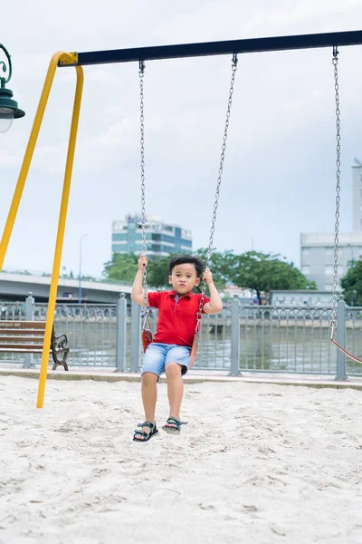 Szczęśliwy Chłopiec Azjatyckich Kołysząc Się Placu Zabaw Parku — Zdjęcie stockowe