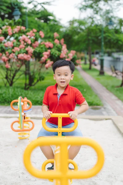 户外跷跷板上的快乐小男孩 — 图库照片