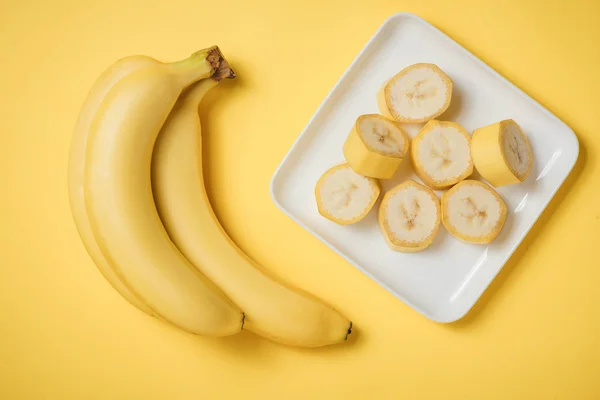 Banana and banana slices on a ceramic disk.