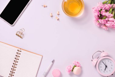 Üstten görünüm Not defteri ve pembe bir arka plan üzerinde çiçekler. Düğün planlayıcısı kavramı için