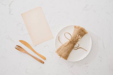 Beslenme kavramı. Kaşık, çatal ve beyaz tabak beyaz taş zemin üzerinde.