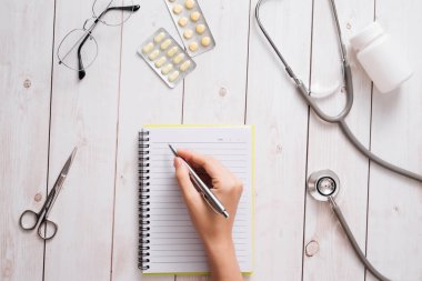 Doktor Danışma Kliniği/Hastanesi'nde tıbbi malzeme ile en iyi görünümü. Stetoskop, reçete Pano ve kopya alanı ile beyaz arka plan üzerinde ilaç şişesi. Sağlık ve tıp kavramı.