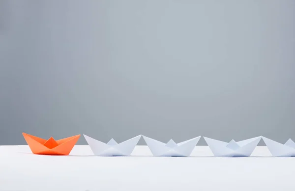 Liderlik kavramı. Beyaz arasında önde gelen kırmızı kağıt gemi