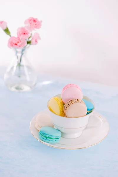 Delicious french dessert. Pink flowers and colorful pastel macaroons