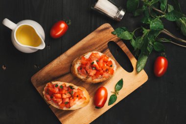 Lezzetli İtalyan bruschetta ekmek domates ve ahşap tahta üzerinde otlar ile tepesinde ile